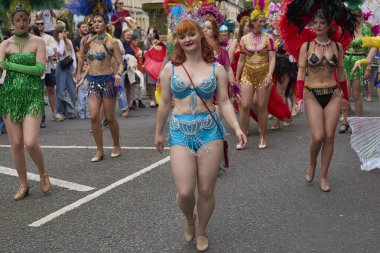 Bath, İngiltere, Birleşik Krallık - 13 Temmuz 2024: Somerset 'teki tarihi Bath kentinin caddelerinde ilerleyen geleneksel karnavalda süslü kostümlü dansçılar.