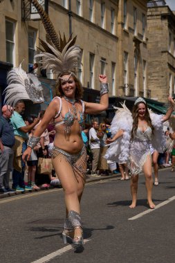 Bath, İngiltere, Birleşik Krallık - 13 Temmuz 2024: Somerset 'teki tarihi Bath kentinin caddelerinde ilerleyen geleneksel karnavalda süslü kostümlü dansçılar.