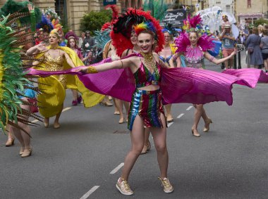 Bath, İngiltere, Birleşik Krallık - 13 Temmuz 2024: Somerset 'teki tarihi Bath kentinin caddelerinde ilerleyen geleneksel karnavalda süslü kostümlü dansçılar.