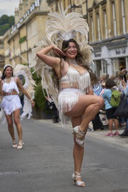 Bath, İngiltere, Birleşik Krallık - 13 Temmuz 2024: Somerset 'teki tarihi Bath kentinin caddelerinde ilerleyen geleneksel karnavalda süslü kostümlü dansçılar.