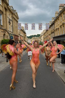 Bath, İngiltere, Birleşik Krallık - 13 Temmuz 2024: Somerset 'teki tarihi Bath kentinin caddelerinde ilerleyen geleneksel karnavalda süslü kostümlü dansçılar.