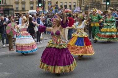 Bath, İngiltere, Birleşik Krallık - 13 Temmuz 2024: Somerset 'teki tarihi Bath kentinin caddelerinde ilerleyen geleneksel karnavalda süslü kostümlü dansçılar.