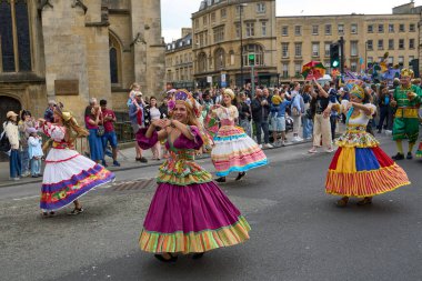 Bath, İngiltere, Birleşik Krallık - 13 Temmuz 2024: Somerset 'teki tarihi Bath kentinin caddelerinde ilerleyen geleneksel karnavalda süslü kostümlü dansçılar.