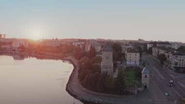 Ternopil, Ukrayna 'nın göl kenarındaki yapıların ve yolların üzerindeki gündoğumunu görüntüleyen hava görüntüsü