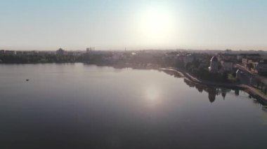 Ternopil, Ukrayna 'nın çarpıcı insansız hava aracı görüntüleri. Huzurlu gölü, şehri ve ılık gün batımını gösteriyor.