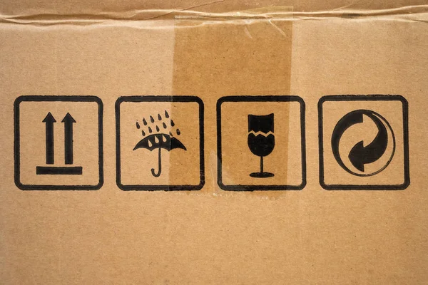 Top, Moisture protection, fragile and Green Dot packaging symbols on  cardboard box, close-up.