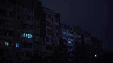 Rusya 'nın elektrik santrallerini bombalaması sonrasında elektrik kesintisi sırasında Kyiv' in yerleşim bölgesinde çok katlı bir apartman binası. Zaman Uygulaması.