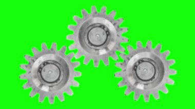 Yeşil bir ekranda üç metal dişli dönmeye, dönmeye ve durmaya başlar..