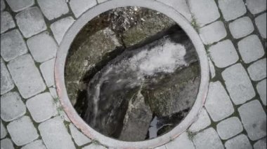 Atık su, kaldırımdaki kanalizasyon çukurunun dibindeki kanalizasyona akıyor..
