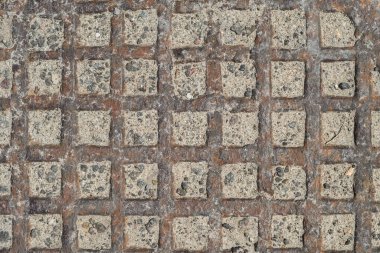 Lattice pattern of rusty metal surface. Part of a metal cast iron disc hatch, close-up.
