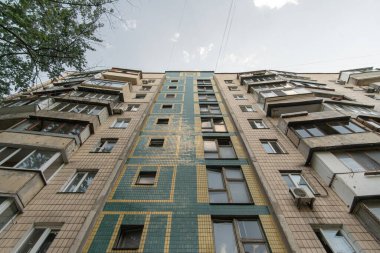Facade of a panel apartment building of a Soviet house lined with glazed ceramic tiles. Bottom-up view.