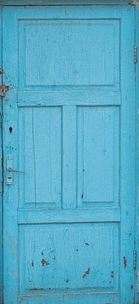 Old shabby blue textured wooden door is isolated.