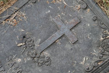 Hıristiyan haçı, 19. yüzyıldan kalma bir metal mezar taşı üzerinde, yakın plan..