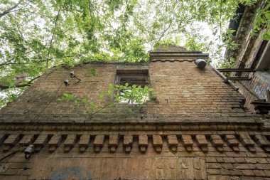 19. yüzyılın terk edilmiş, harap olmuş tuğla binasının ön cephesi kırılmış..