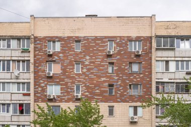 Çok katlı bir apartmanın ön cephesi renkli parlak seramik fayanslarla kaplıdır. Kyiv, Ukrayna - Mayıs 2021.