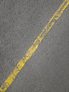 Asfalttaki sarı çapraz yol işaretleme çizgisi.