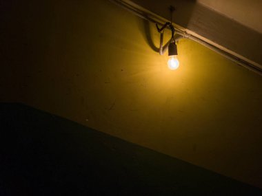 Tungsten ampulü duvardaki eski karanlık bodrumda.