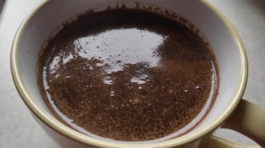 Beyaz mutfak masasında bir fincan kahve. Kapat..