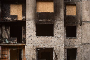 Kyiv, Ukrayna - 18 Şubat 2024: Rus ordusu tarafından bombalanan ve sonradan kontrplakla kaplanan konut binasının pencereleri.