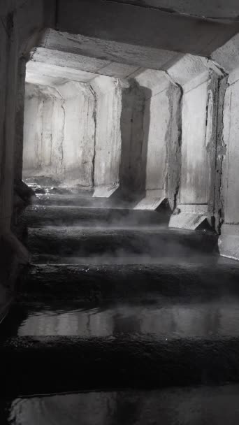 正方形混凝土排水隧道 蒸汽从水中蒸发 有台阶的混凝土下水道隧道转弯 转弯后闪烁着光芒 — 图库视频影像