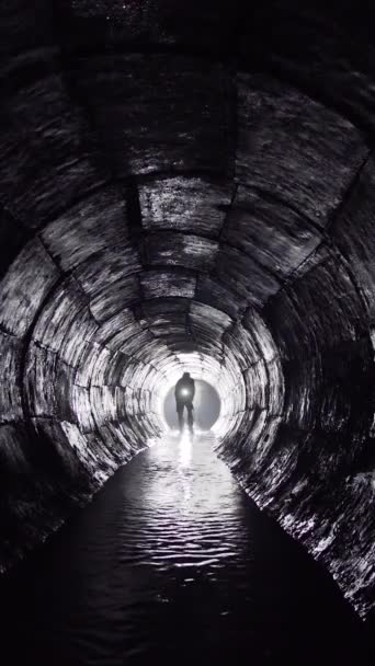 一个拿着灯笼的人走在地下的混凝土集雨器里 — 图库视频影像