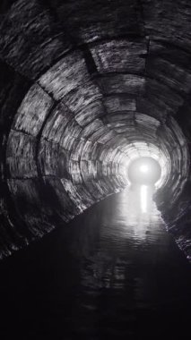 Yuvarlak drenaj beton tünel, biçimsel çalışmayla inşa edilmiş su. Sonunda ışık var. Tüpün içine gizlenmiş yeraltı nehri.