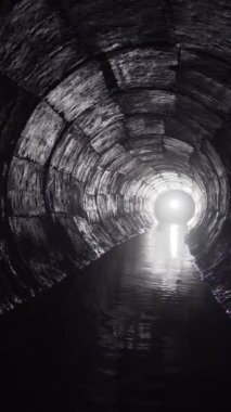 Yuvarlak drenaj beton tünel, biçimsel çalışmayla inşa edilmiş su. Sonunda ışık var. Tüpün içine gizlenmiş yeraltı nehri.