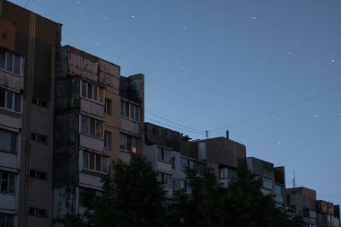 Rusya 'nın elektrik santrallerini bombalaması sonrasında Kyiv' in yerleşim alanındaki elektrik kesintisi sırasında çok katlı apartmanın pencerelerinden birinde ışık yandı. Kyiv, Ukrayna - Haziran 2024.