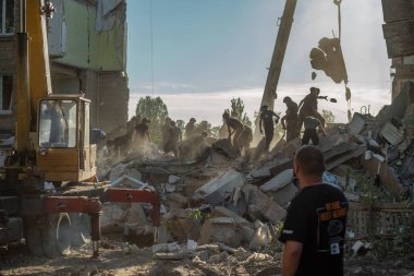 KYIV, UKRAINE - 8 Temmuz 2024: Acil servis çalışanları, Kyiv 'in yerleşim bölgelerinden birinde bir Rus füzesinin bir yerleşim bölgesine isabet etmesi sonrasında enkaz yığınını parçalara ayırdı.