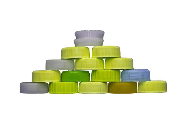 stock image Yellow plastic HDPE caps pyramide from drinking water bottles isolated on a white background.