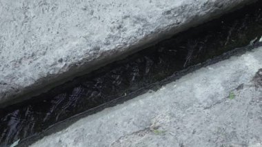 Yağmur suyuyla beton kaldırım drenajı, üst manzara.