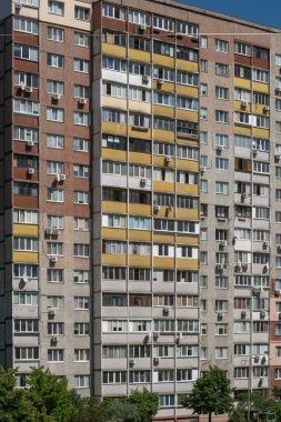 Sıcak bir yaz gününde, çok katlı prefabrik bir panelin aşırı kalabalık, pejmürde apartmanının ön cephesi. Kyiv, Ukrayna - 25 Mayıs 2024
