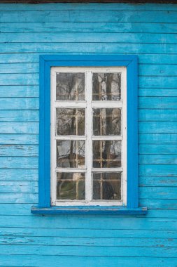Ahşap tahtayla boyanmış bir duvarın üzerindeki eski beyaz ahşap pencere..