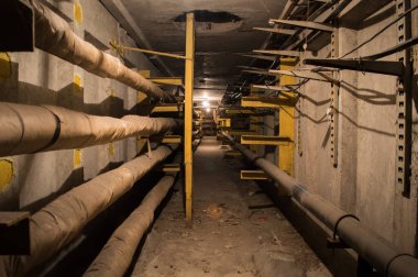 Yeraltı beton tünel boruları ve kabloları tungsten ampulleri tarafından aydınlatılıyor. Bu tünel sanayi ve apartmanlar için enerji, su ve ısı sağlıyor..