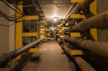Yeraltı beton tünel boruları ve kabloları tungsten ampulleri tarafından aydınlatılıyor. Bu tünel sanayi ve apartmanlar için enerji, su ve ısı sağlıyor..