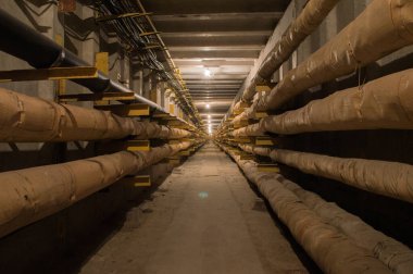 Yeraltı beton tünel boruları ve kabloları tungsten ampulleri tarafından aydınlatılıyor. Bu tünel sanayi ve apartmanlar için enerji, su ve ısı sağlıyor..