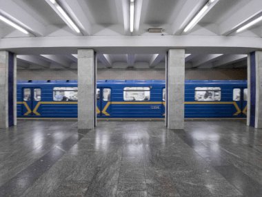 Metro istasyonundaki tren hareket halinde, yan görüş, boş istasyon. Poshtova ploscha, Kyiv, Ukrayna.