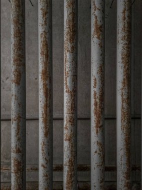 Endüstriyel bir iç mekanda beton bir duvarda paslı borular..