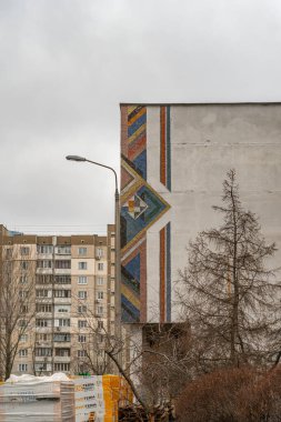 Poznyaky yerleşim bölgesinde bulutlu bir günde 1990 'ların başında oluşturulan okul cephesindeki küçük soyut mozaik, yakın plan. Kyiv, Ukrayna - 28 Aralık 2024