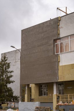 Poznyaky yerleşim bölgesinde bulutlu bir günde okul cephesine dış izolasyon kurulumu, kapatın. Kyiv, Ukrayna - 28 Aralık 2024