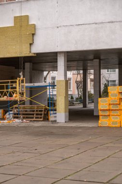 Installation of external insulation on the school facade on a cloudy day in the Poznyaky residential area, close up. Kyiv, Ukraine - December, 28, 2024 clipart