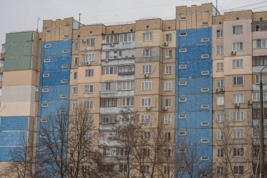 Eski prefabrik dokuz katlı apartman dairesi iki mavi girişi olan bej seramik seramik karoları kaplamıştı. Kyiv, Ukrayna - 15 Şubat 2025.