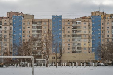 Eski prefabrik dokuz katlı apartman dairesi üç mavi girişi olan bej seramik seramik kiremitlerle kaplıydı. Kyiv, Ukrayna - 15 Şubat 2025.