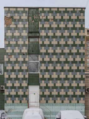 1980 'lerden kalma eski bir alışveriş merkezinin duvarındaki yeşil bej ve gri seramik döşeme deseni. Kyiv, Ukrayna - 15 Şubat 2025.