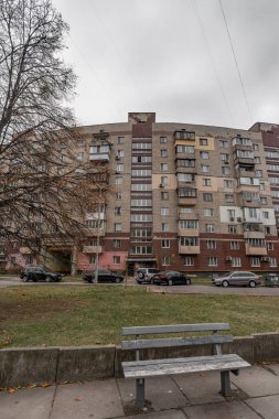 Sovyet döneminden kalma seramik fayanslarla kaplı, ön planda bir bank olan kavisli tuğla bina. Synyozernyi bölgesinde, Kyiv, Ukrayna. Ekim 2024.