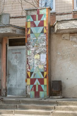 Prefabrik bir apartmanın girişindeki seramik fayans paneli, kısmen reklamlarla kaplı. 1980 'lerin başında yaratılmış. Kalynivka, Brovary bölgesi, Kyiv bölgesi, Ukrayna - 8 Mart 2025.