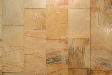 Duvar dikdörtgen bej mermer karolarla kaplı. Damarları ve dokusu parlatılmış doğal taş yüzeyi..