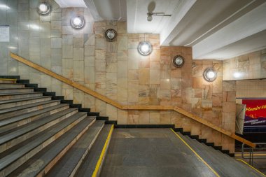 Poshtova Ploshcha metro istasyonunda mermer duvarları ve yuvarlak lambaları olan merdiven. Kyiv, Ukrayna 29 Mart 2025.