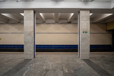 Poshtova Ploshcha metro istasyonunun içi. İstasyonda kare mermer sütunlar ve doğrusal floresan ışıklandırmadan oluşan bir sütunlu merkezi platform yer alıyor. Kyiv, Ukrayna - 29 Mart 2025.