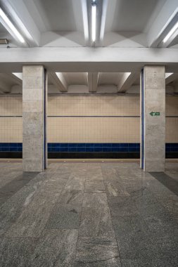 Poshtova Ploshcha metro istasyonunun içi. İstasyonda kare mermer sütunlar ve doğrusal floresan ışıklandırmadan oluşan bir sütunlu merkezi platform yer alıyor. Kyiv, Ukrayna - 29 Mart 2025.